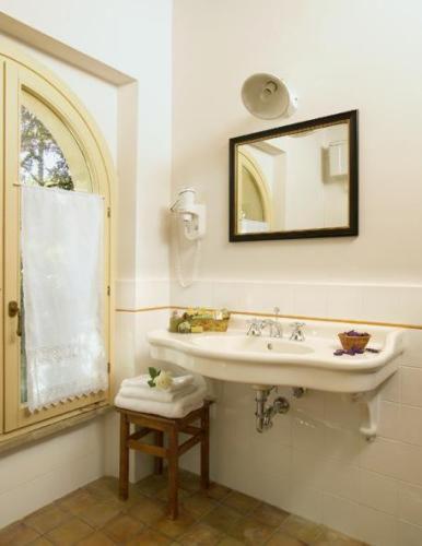 a bathroom with a sink and a mirror at La Locanda del Borgo in Pietralunga