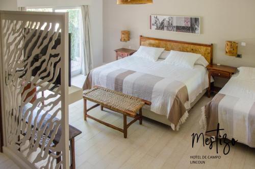 Un dormitorio con una cama y una silla y una ventana. en Mestizo Hotel, en Lincoln