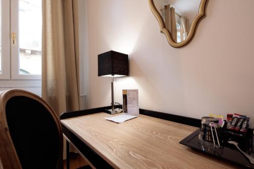 a table with a lamp on top of it at Hôtel La Résidence in Narbonne