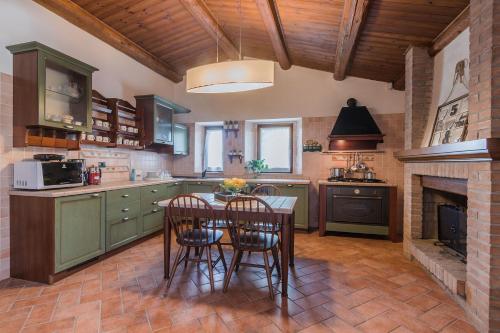 a kitchen with a table and chairs and a fireplace at Villa Durante in Cagli