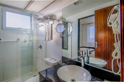 a bathroom with a sink and a glass shower at Klein Ville São Leopoldo in São Leopoldo