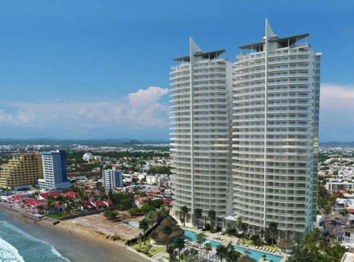 two tall buildings on the beach next to the ocean at Camino al Mar exclusivo Departamento acceso directo playa in Mazatlán