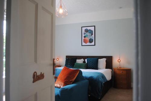 a bedroom with a bed and a blue couch at Penygelli Apartments in Newtown