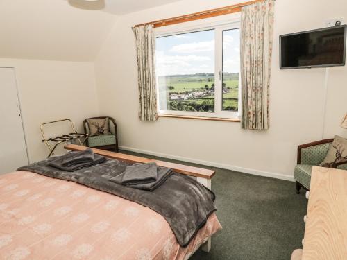 a bedroom with a bed and a window at Rose Bank in Belford