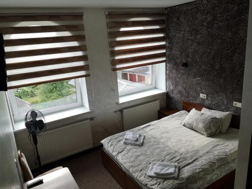 a bedroom with a bed and two windows at Pas Nerijų in Skuodas
