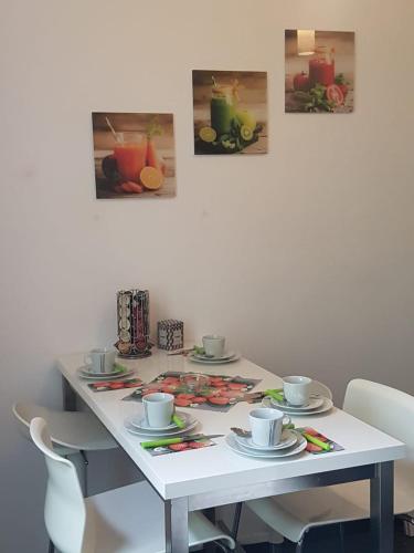 a white table with cups and saucers on it at Ferienwohnung Gmünd in Gmünd