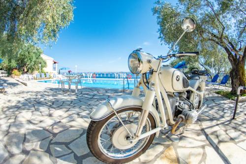 a white motorcycle parked on a stone ground at Amalia Complex in Nisakion