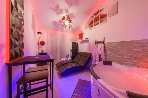 sala de estar con bañera y sofá en Love Room - Suite romantique avec spa privatif, en Le Puy en Velay