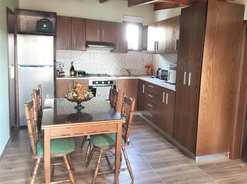 a kitchen with a table and chairs and a refrigerator at Lovely house not far from the beach, near Protaras in Dherinia