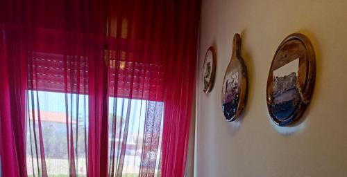 Zimmer mit zwei Uhren und einem Fenster mit roten Vorhängen in der Unterkunft MSCamere in Termoli