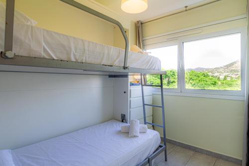 a room with two bunk beds and a window at Apartamento Cabrera Montserrat in Cabrera de Mar