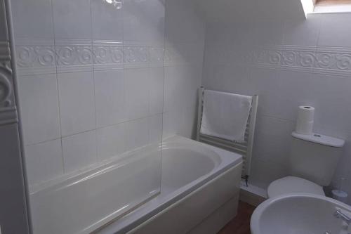 La salle de bains blanche est pourvue d'une baignoire et de toilettes. dans l'établissement The Stable, à Aberystwyth