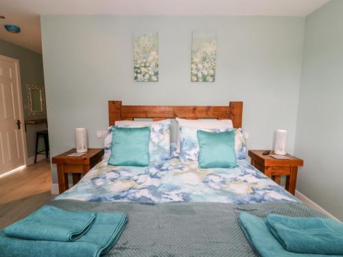 a bedroom with a bed with blue pillows at Meadowbank Lodge in Brandesburton