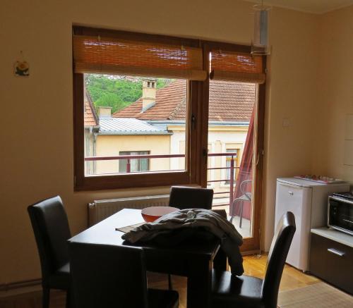 uma sala de jantar com uma mesa e uma grande janela em Apartmani Bambola em Višegrad