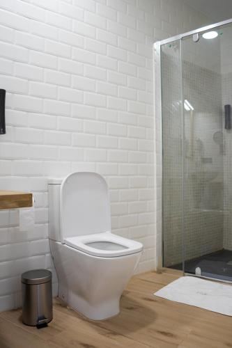 a bathroom with a toilet and a glass shower at Balhondo Open Village in Puebla de Alcocer