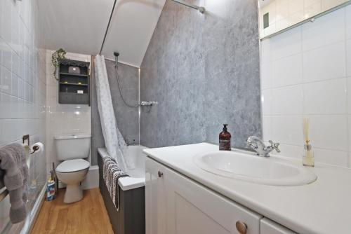 Baño blanco con lavabo y aseo en Compton House Snug, en Newark-on-Trent