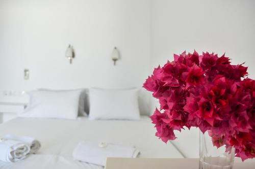 a vase filled with red flowers sitting on a table at Village Twins 1 in Ios Chora