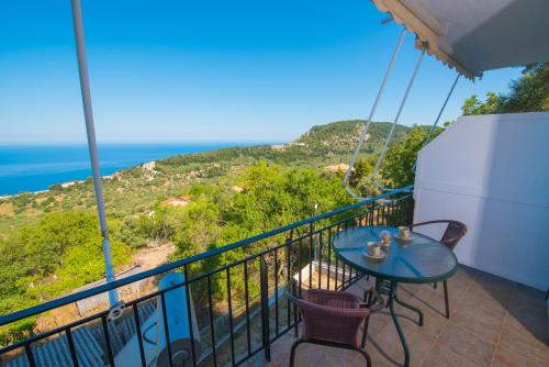 a balcony with a table and chairs and the ocean at Elena Studios in Athanion