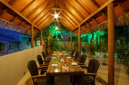 een eetkamer met een lange tafel en stoelen bij Koimala Beach Ukulhas in Ukulhas