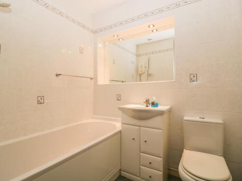 uma casa de banho com um lavatório, uma banheira e um WC. em Skylark em Weymouth