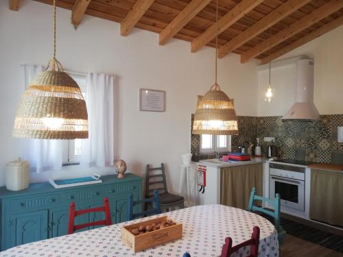 a kitchen with blue cabinets and a table in a room at Burrico D`Orada - Lodging & Experiences in Pedrógão