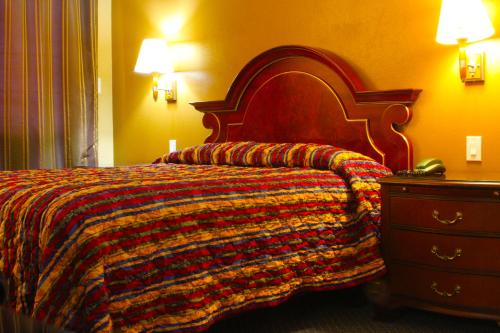 a bedroom with a bed with a colorful blanket and a dresser at Redondo Beach Inn-LAX in Gardena