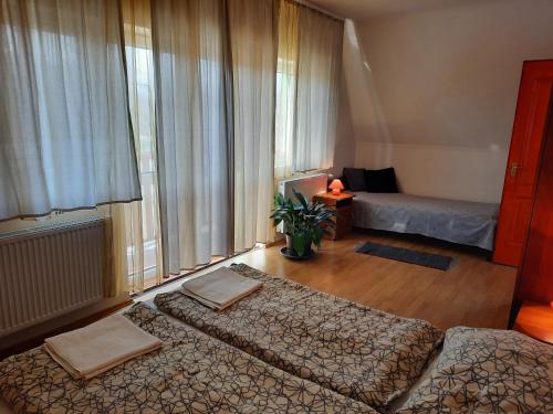 a bedroom with two beds and a large window at Megálló Wellness Panzió in Pálháza