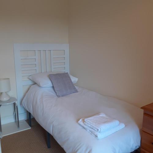 a bedroom with a white bed with towels on it at 2 Bodwen Villas in Llangollen