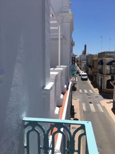 a balcony of a building with a view of a street at HOSTAL LA CRUZ 1872 in Chipiona