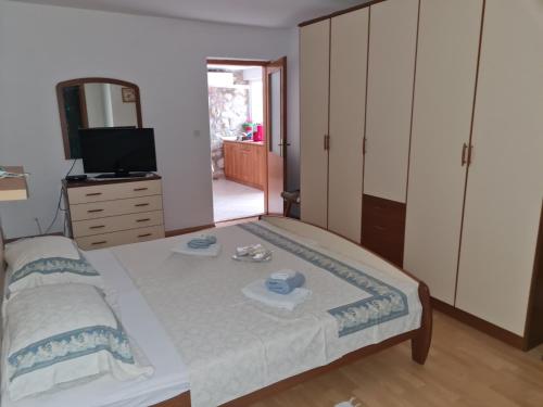 Schlafzimmer mit einem Bett, einem TV und einer Kommode in der Unterkunft Apartment Mihael in Dubrovnik