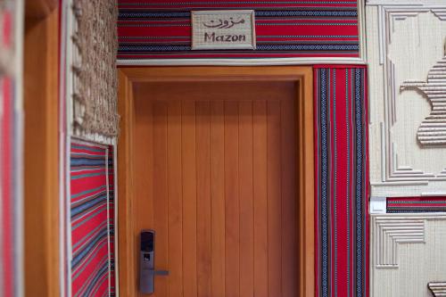 a door of a building with a sign above it at Fort Guesthouse نُزل القلعة in Muscat