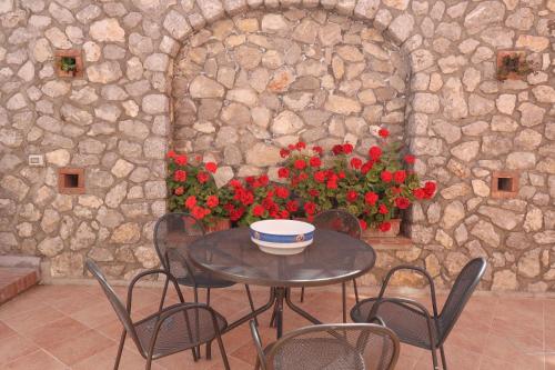 a table and chairs in a stone room with flowers at Casa di charme panoramica a Capri sulla spiaggia. in Capri