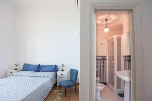 a bedroom with a bed and a toilet and a sink at Casa di charme panoramica a Capri sulla spiaggia. in Capri