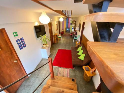 Habitación con escalera y alfombra roja. en Pucontours Hostal, en Pucón