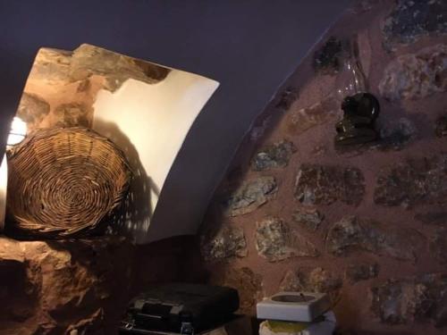um quarto com uma parede de pedra e um quarto com em Aroma Avlis Apartment em Areopoli