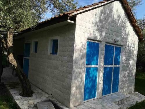 a small brick house with blue windows at Rajana Bungalow 2olive House in Ulcinj