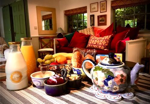 Charming Victorian Coach House في Jordanstown: طاولة مع إبريق من الحليب ووعاء من الفاكهة