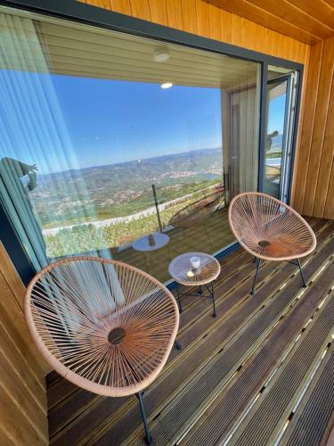 three chairs and tables on a balcony with a view at Paraiso Douro in Lamego