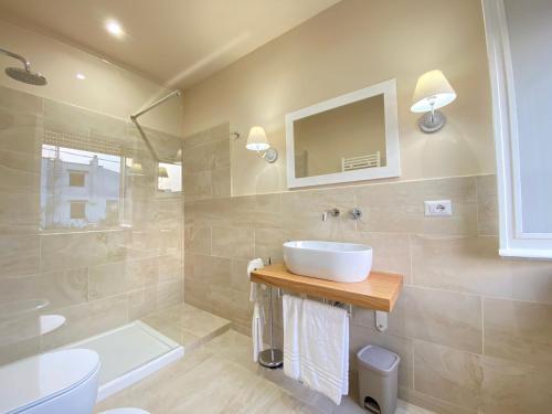 a bathroom with a sink and a toilet and a mirror at Maison Sciscì in San Felice Circeo