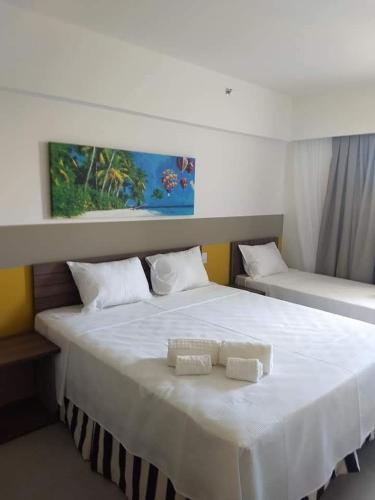 uma grande cama branca com duas toalhas brancas em OLÍMPIA - Thermas - Resort Maravilhoso! em Olímpia