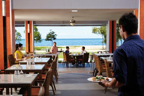 een man die eet in een restaurant met uitzicht op de oceaan bij Riu Palace Costa Rica - All Inclusive in Coco