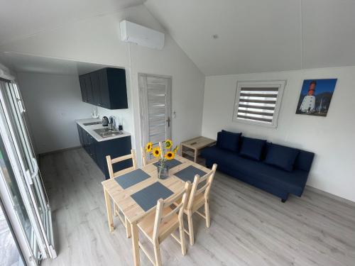 sala de estar con mesa y sofá azul en Premium Home Rozewie en Władysławowo