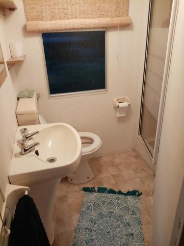 a bathroom with a sink and a toilet and a window at domek na lace in Wisła