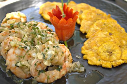 a plate of food with shrimp and other foods at Hotel Checkin El Cortecito Beach in Punta Cana