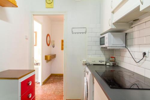 una cucina con piano di lavoro e mobile rosso di Sant Mateu 30 min to Barcelona next beach a Vilassar de Mar