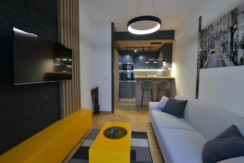 uma sala de estar com um sofá branco e uma mesa amarela em Ragioniere em Vrnjačka Banja
