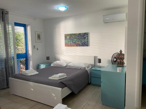 una camera da letto con un letto con armadi blu e un dipinto di B&B ViaDelMare a Patù