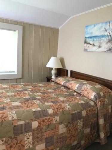 a bedroom with a bed with a quilt on it at Kennebunk Gallery Motel and Cottages in Kennebunk
