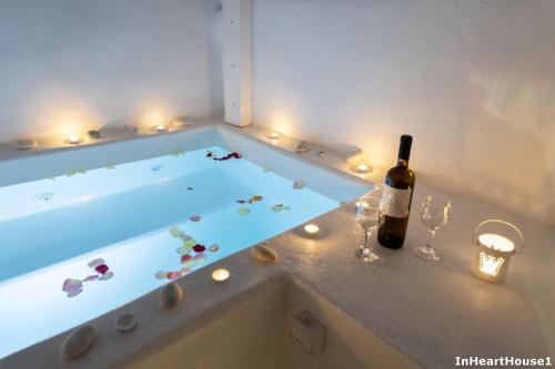 a bath tub with a bottle of wine and wine glasses at In Heart House - Naousa, Paros in Naousa