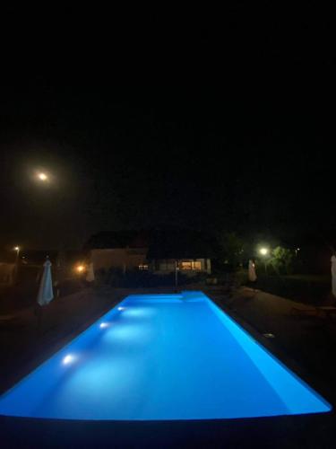a blue swimming pool lit up at night at Villa Stone in Rakovica